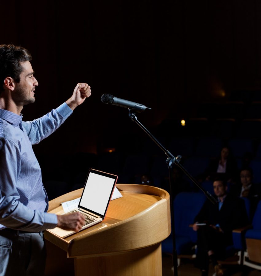 Male business executive giving a speech at conference center